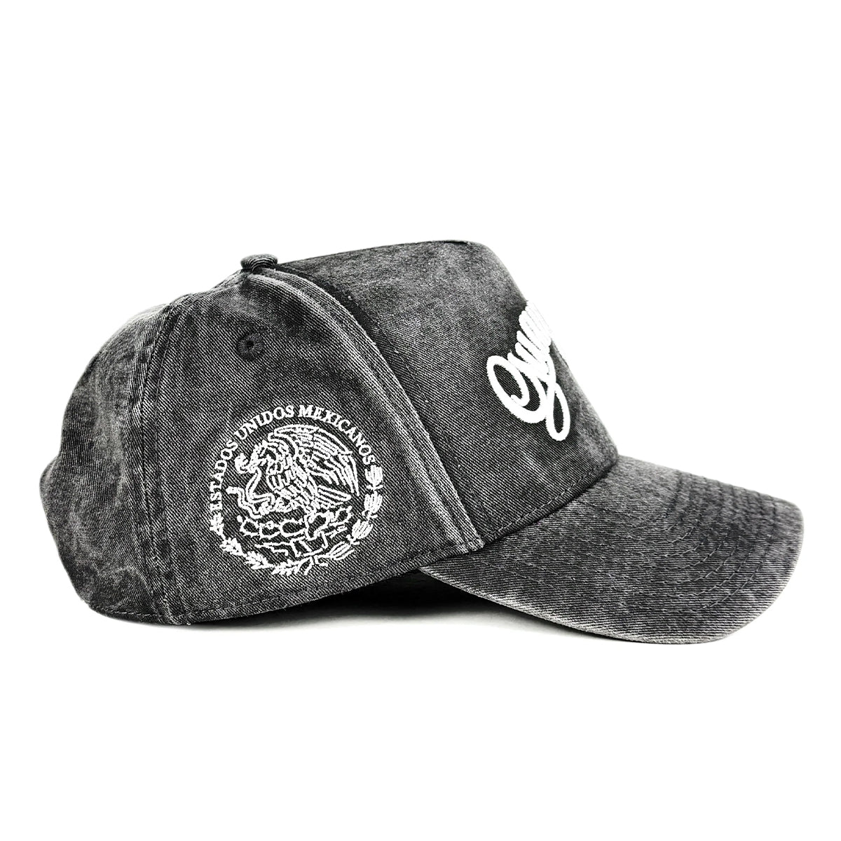 A dark gray acid-wash baseball cap featuring a white embroidered Mexican coat of arms on the side, set against a plain white background.