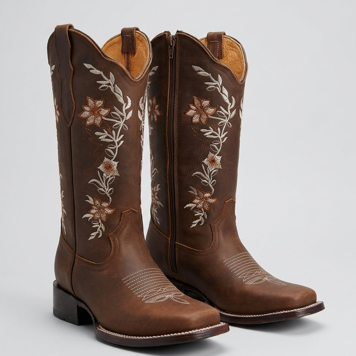 La Sierra women's brown leather cowboy boots with white floral embroidery on the shafts, shown against a light gray background.