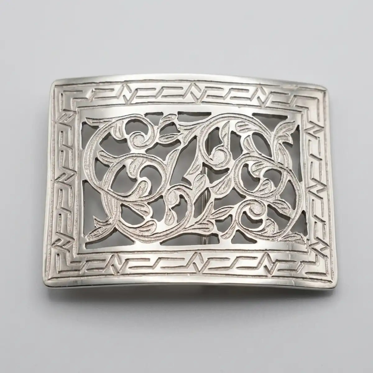 Studio front view of the 4" x 3" stainless steel cutout rectangular belt buckle showing the center scrollwork and geometric frame.