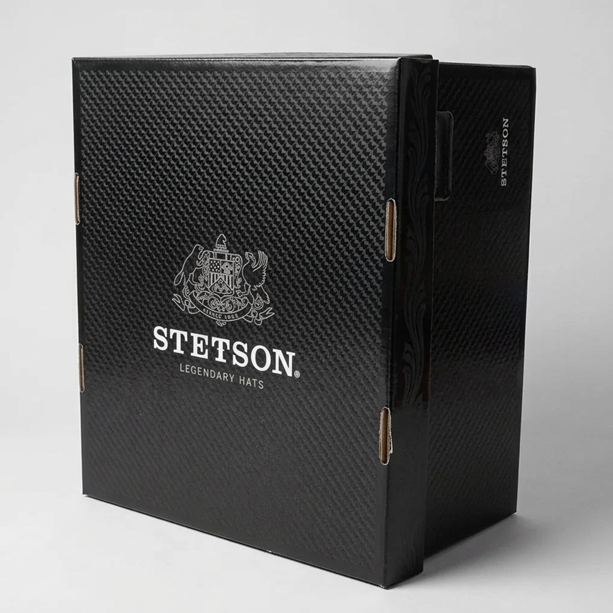 A black textured Stetson hat box with the Stetson crest and 'STETSON LEGENDARY HATS' printed in white on the front, photographed on a light gray background.