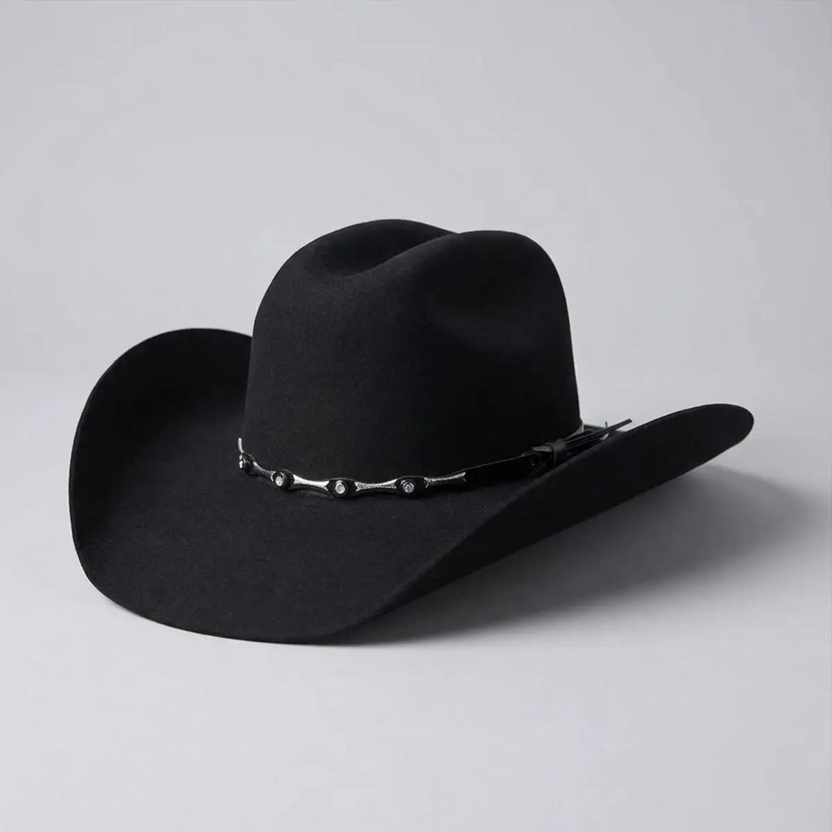 Three-quarter rear studio view of the El General Toro black 50X wool Western hat showing the cattleman crown, 4" brim curvature, and silver studded hatband.