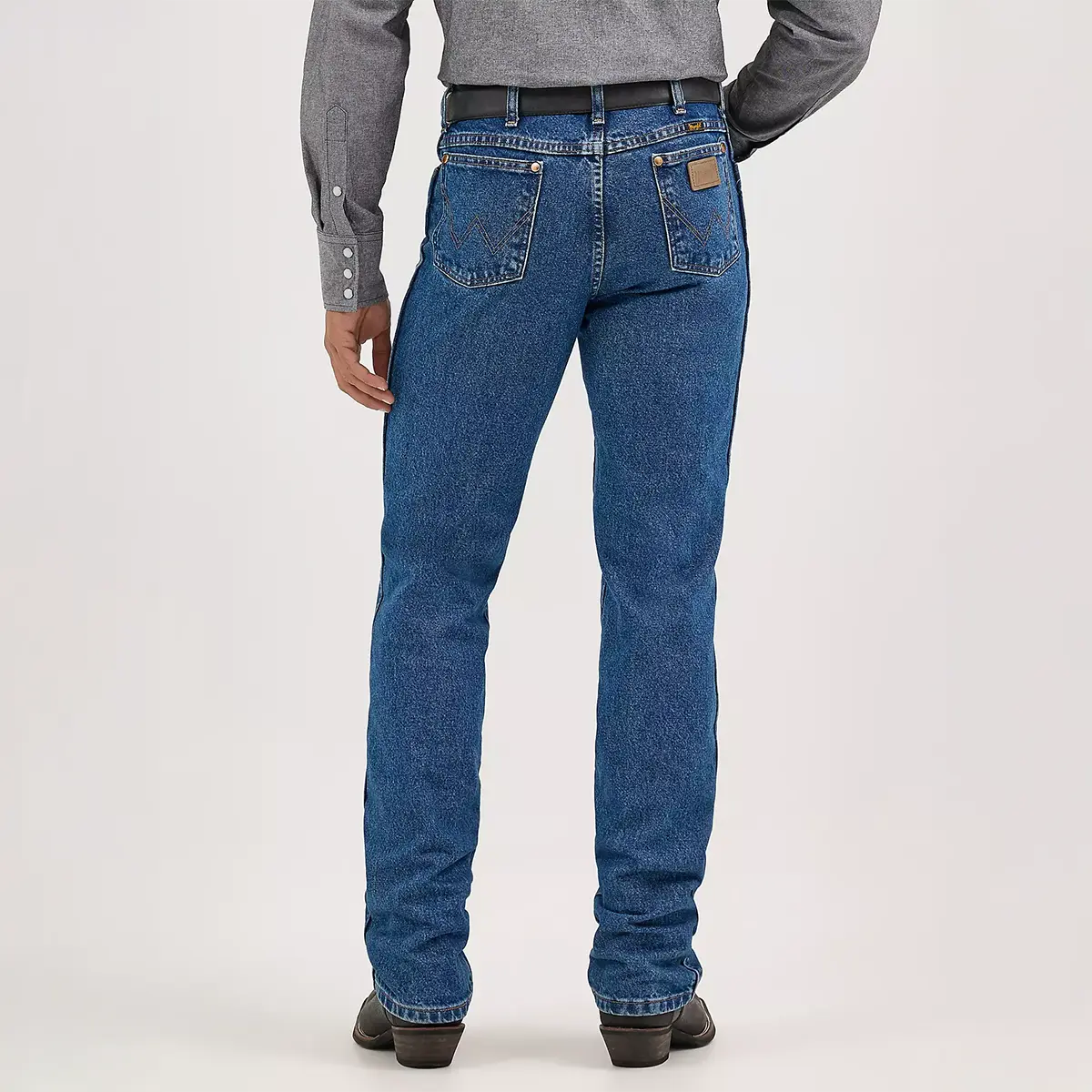 Rear view of the model highlighting the high-rise waist, 'W' embroidered back pockets, and neolite patch on the Wrangler Cowboy Cut slim fit jeans.