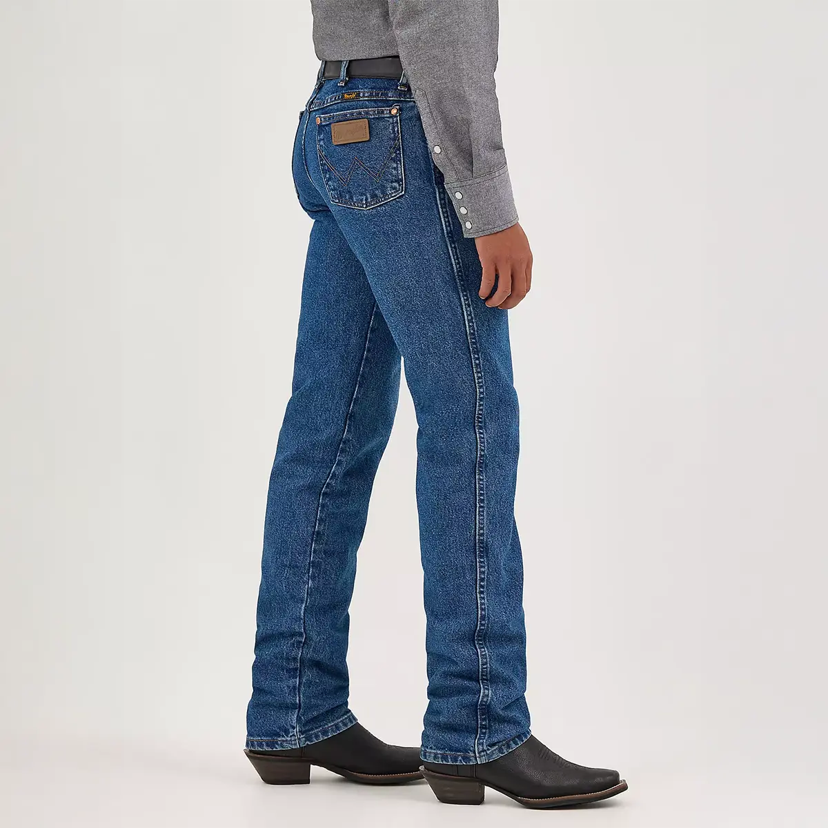 Side profile view of the Wrangler Cowboy Cut slim fit stonewash jeans showing the fitted leg profile and how the 16 1/2" tapered leg fits over cowboy boots.