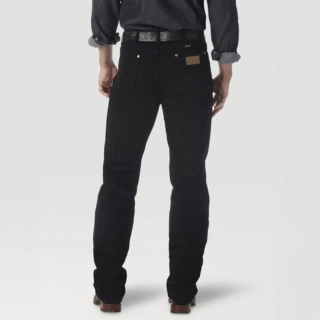 Rear studio view of the Wrangler Cowboy Cut Slim Fit black jeans highlighting the leather brand patch and signature 'W' pocket stitching.
