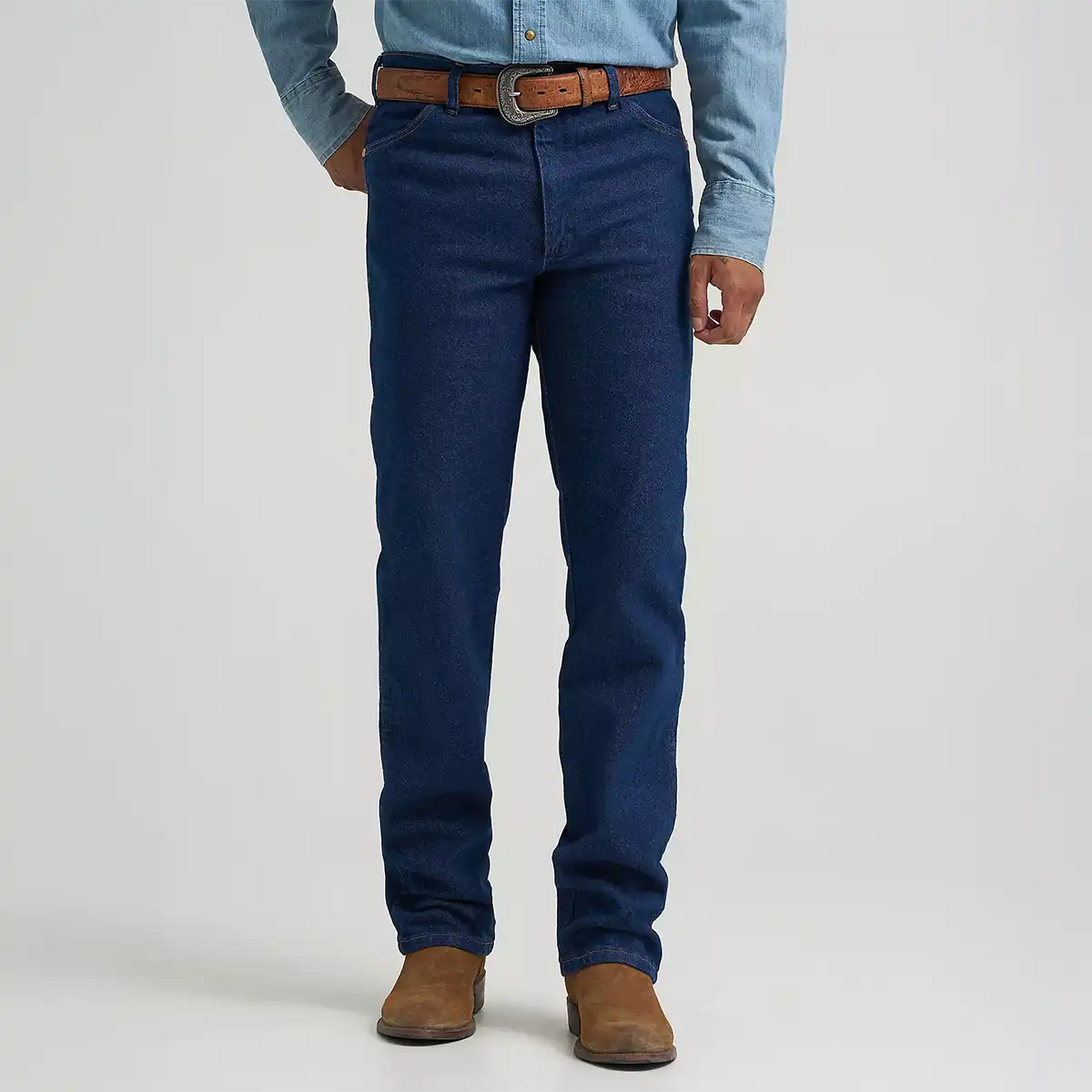 Front view of a man wearing Wrangler Men's Cowboy Cut navy stretch slim fit jeans with a leather belt and suede cowboy boots.