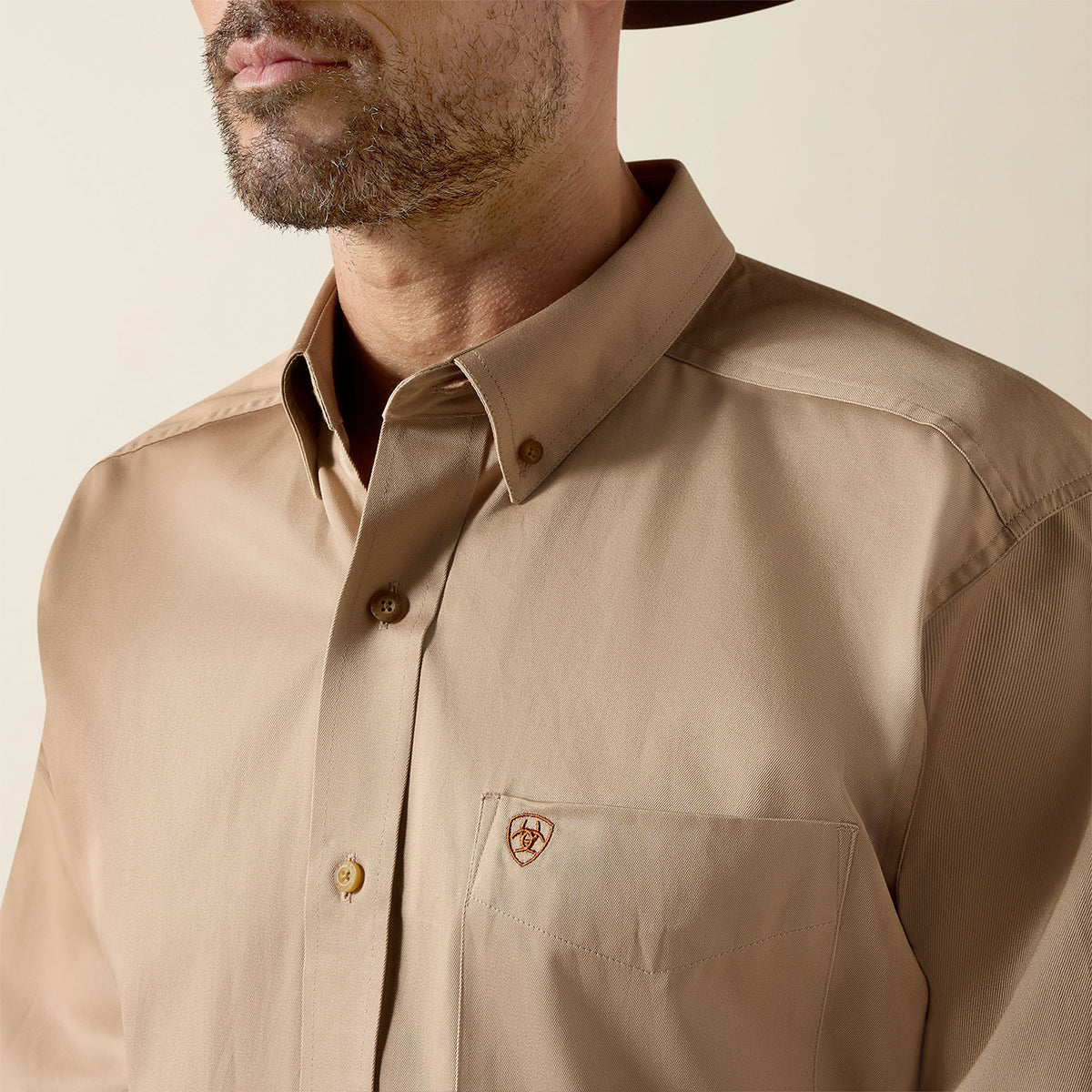 Close up  view of a man wearing the Ariat Men's Solid Twill Khaki button-down shirt.