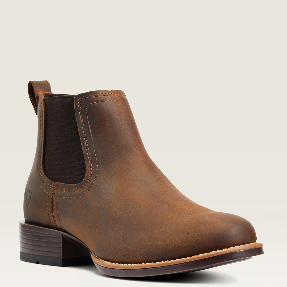 Ariat Men’s Booker Round Toe Ankle Boot in distressed brown full-grain leather featuring elastic side panels, a 1.5-inch stockman heel, and a single-stitched welt.