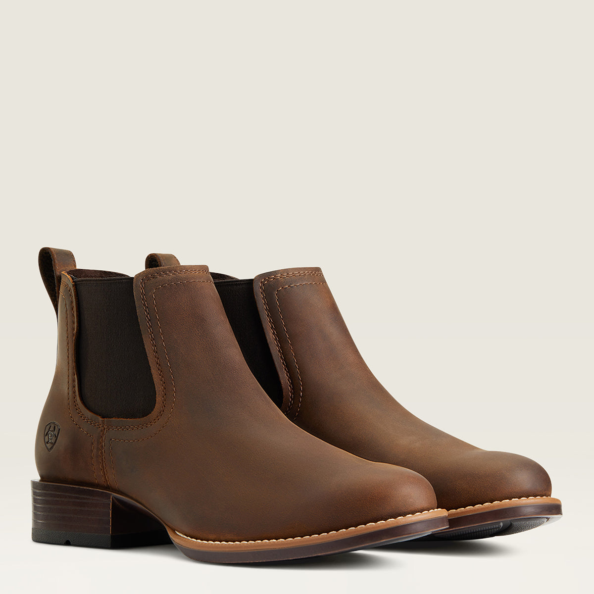 Pair of Ariat brown leather round toe Chelsea boots on a white background.
