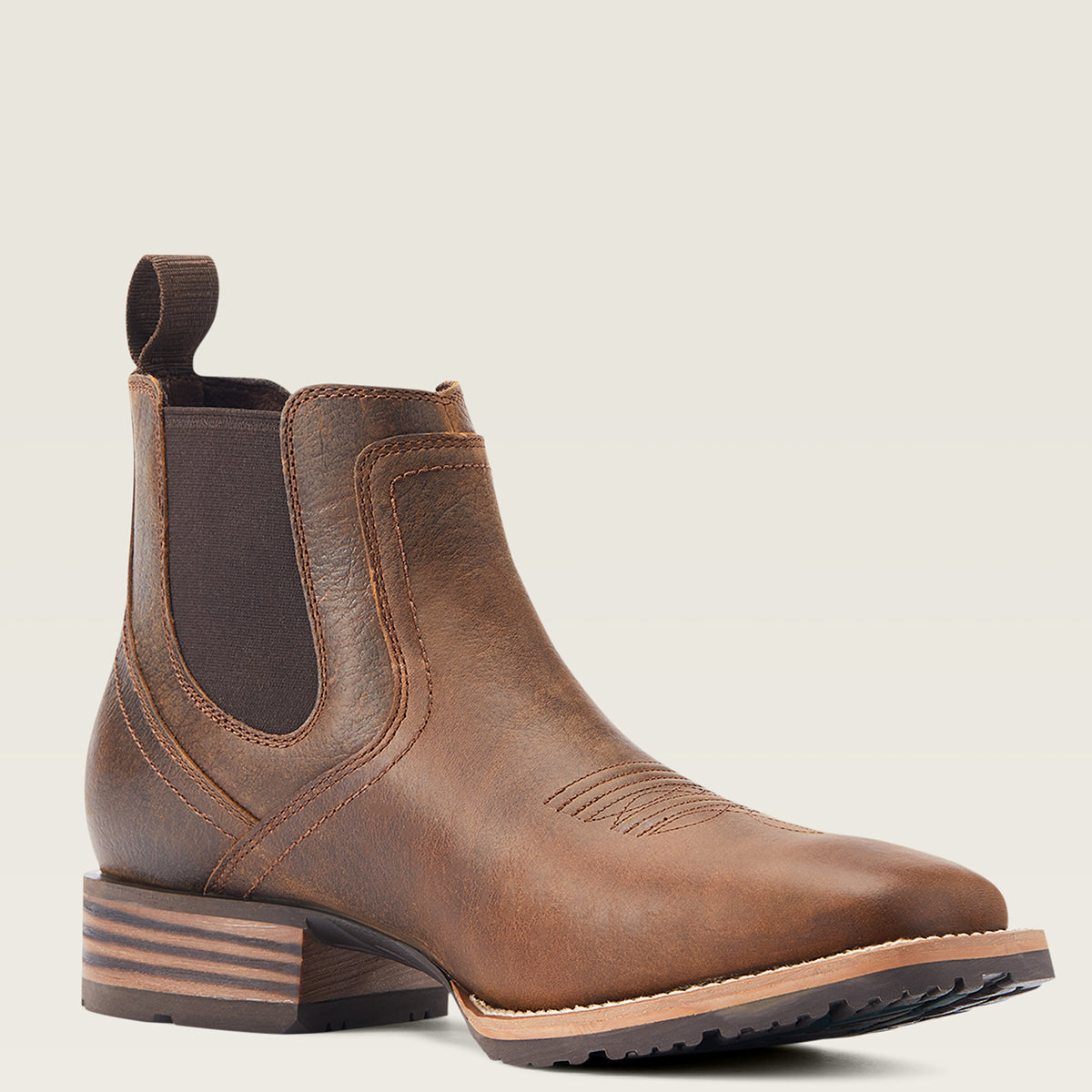 Ariat Men’s Hybrid Low Boy Square Toe Cowboy Ankle Boot in Old Earth brown leather featuring elastic side panels, front and back pull tabs, and a grippy rubber outsole.