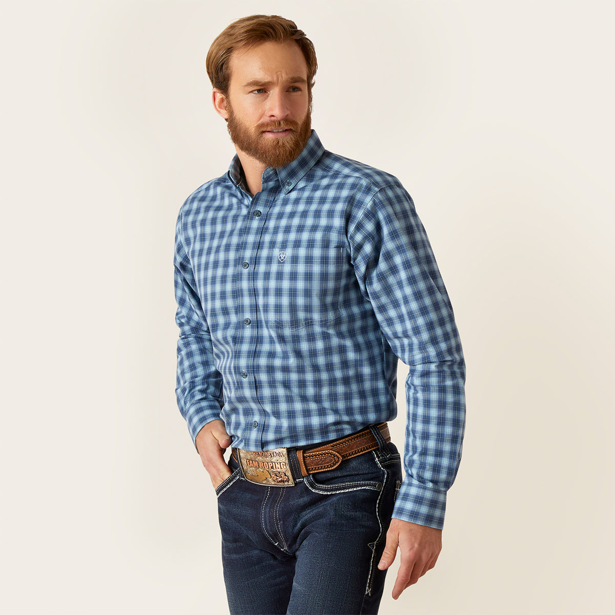 Front view of a man wearing the Ariat Men's Pro Series Gradison Sky Blue plaid long sleeve fitted button-down shirt with hat and jeans.