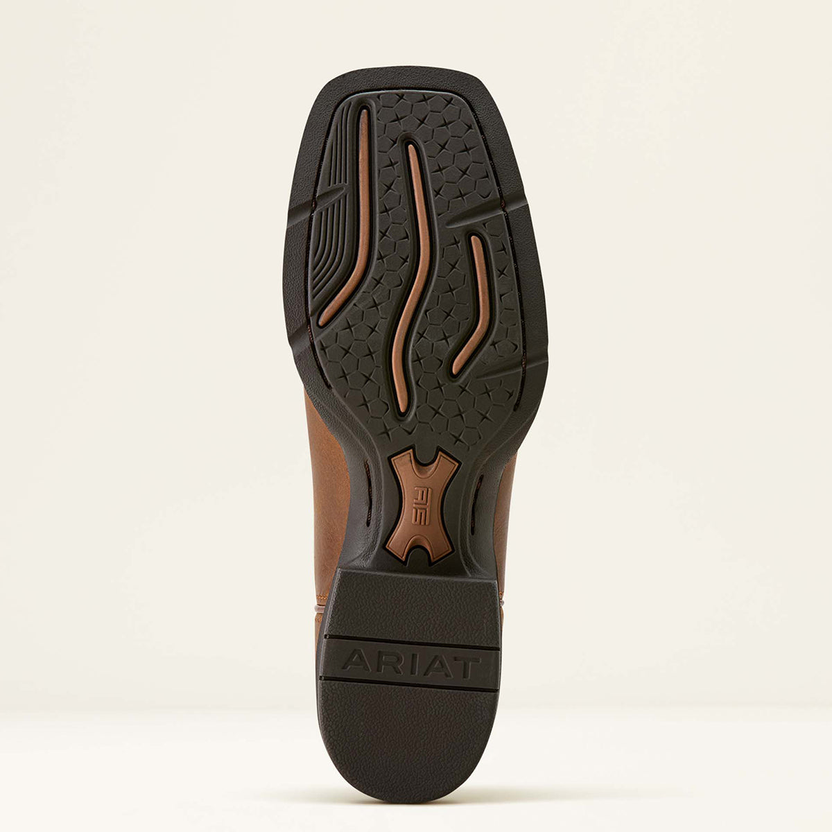 The outsole of a brown leather Ariat boot with a black treaded rubber sole, showing the Ariat logo and brand name on the heel.
