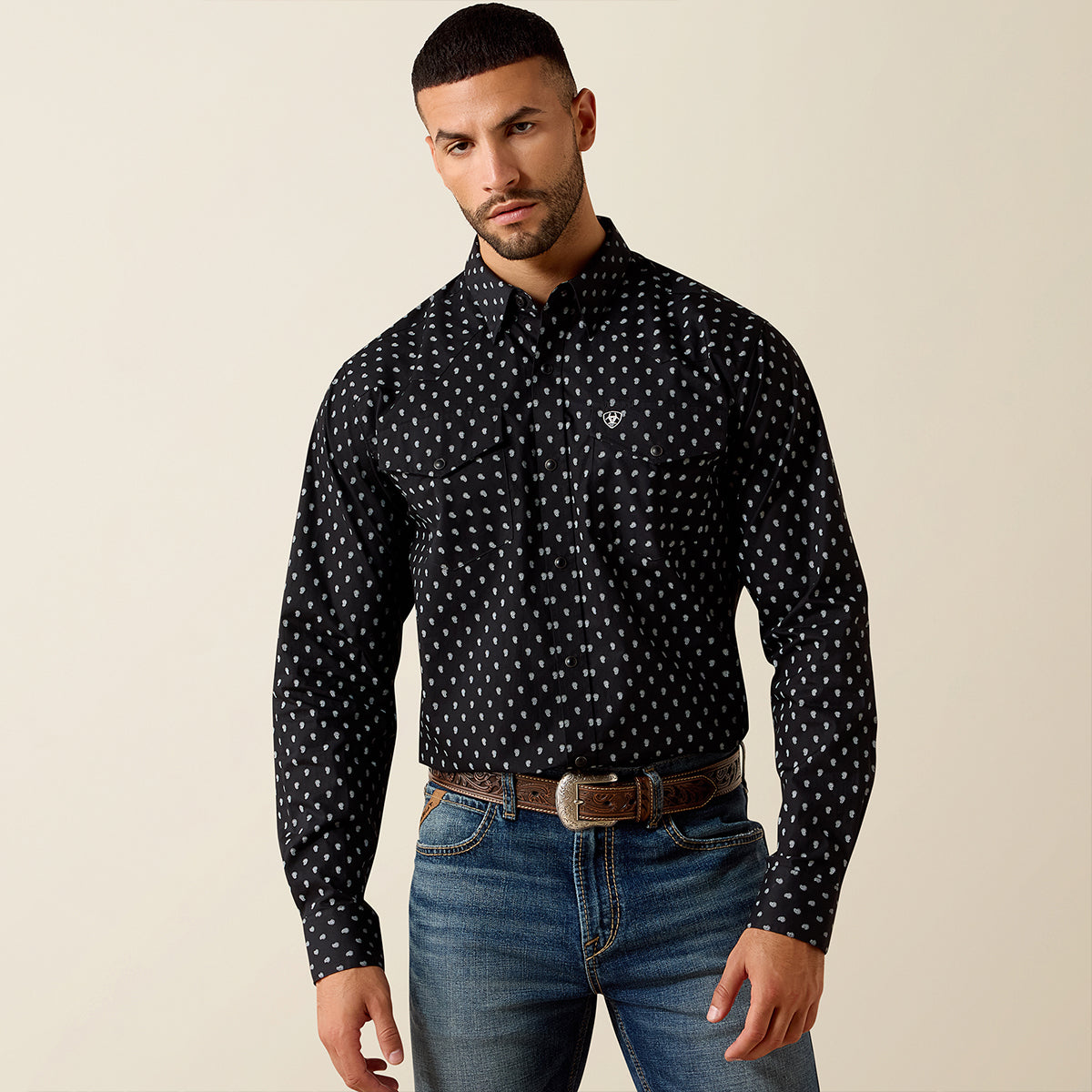 Front view of a man wearing the Ariat Men's Black Paisley Truth Fitted long sleeve Western snap shirt with chest flap pockets.