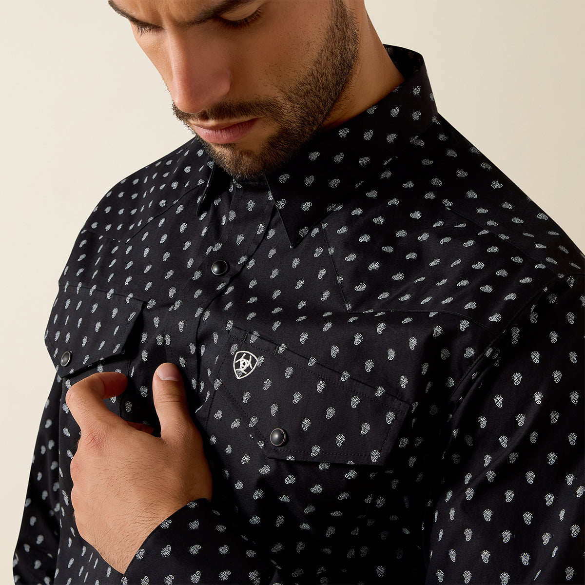Close up of Full-body man wearing the Ariat Men's Black Paisley Truth Fitted long sleeve Western snap shirt.