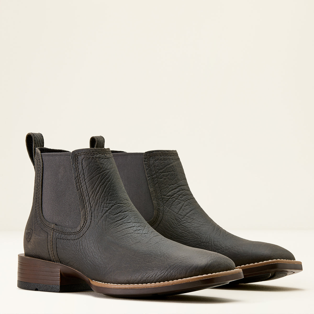 Ariat men's dark charcoal gray leather Chelsea square toe boots with a low stacked heel and brown sole, photographed on a clean off-white background.