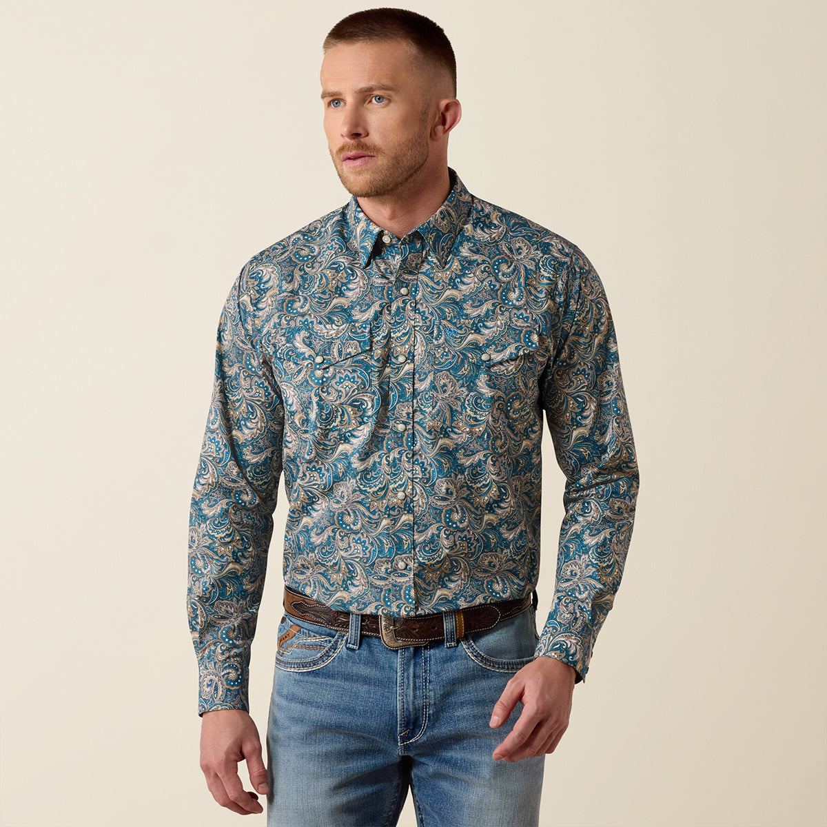 Front and full-body views of a man wearing the Ariat Men's Cedric Blue Paisley print long sleeve Western snap shirt with jeans.