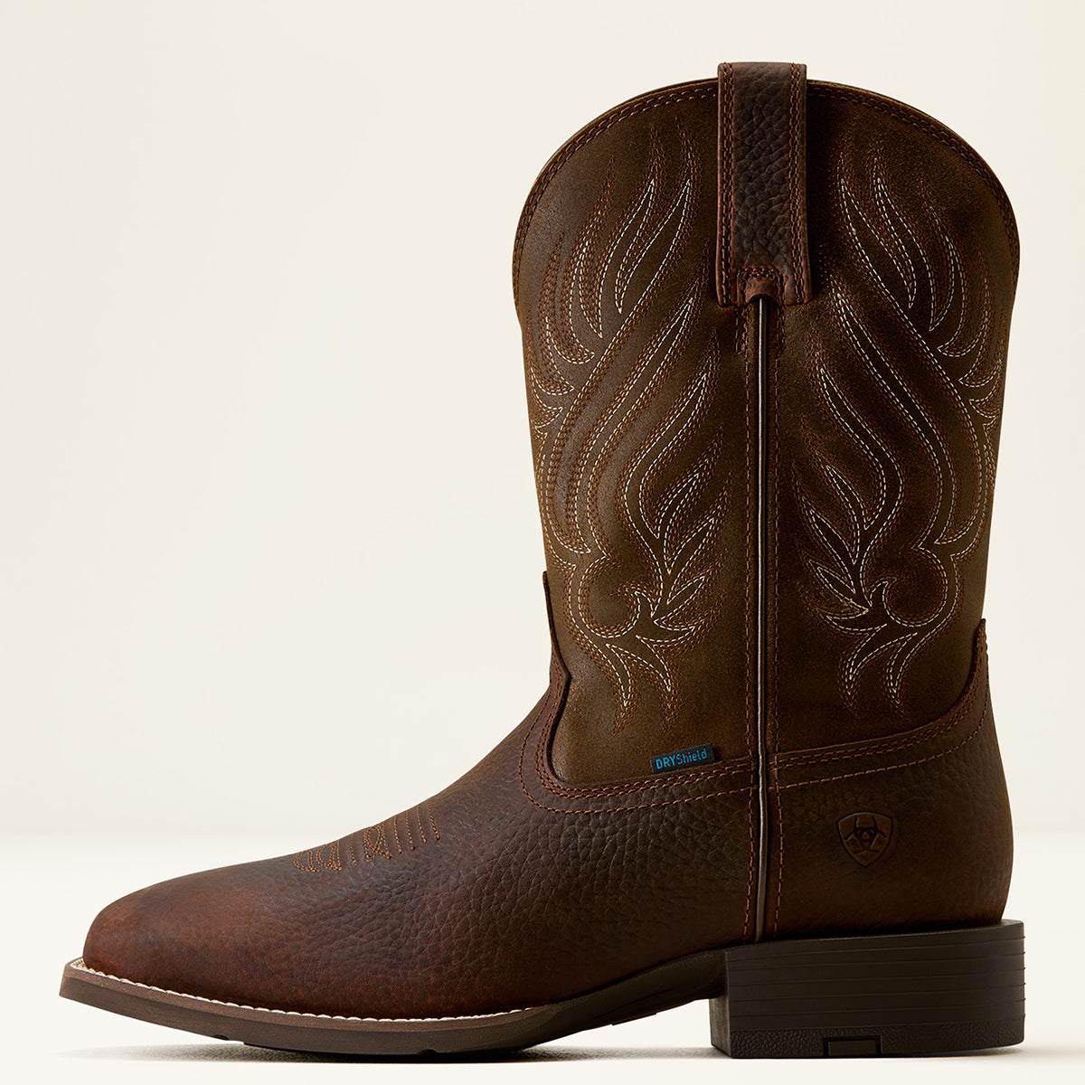 Ariat men's dark brown leather western boot with western embroidery on the shaft, shown in a side profile against a light beige background.