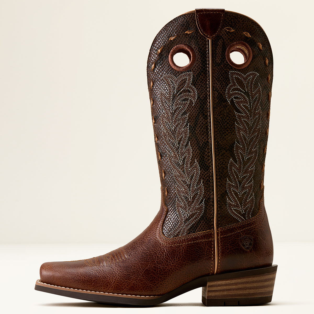 Ariat women's brown leather cowboy boot with a textured snakeskin-patterned shaft, decorative stitching, and a stacked wood-look heel, shown against a plain light background.