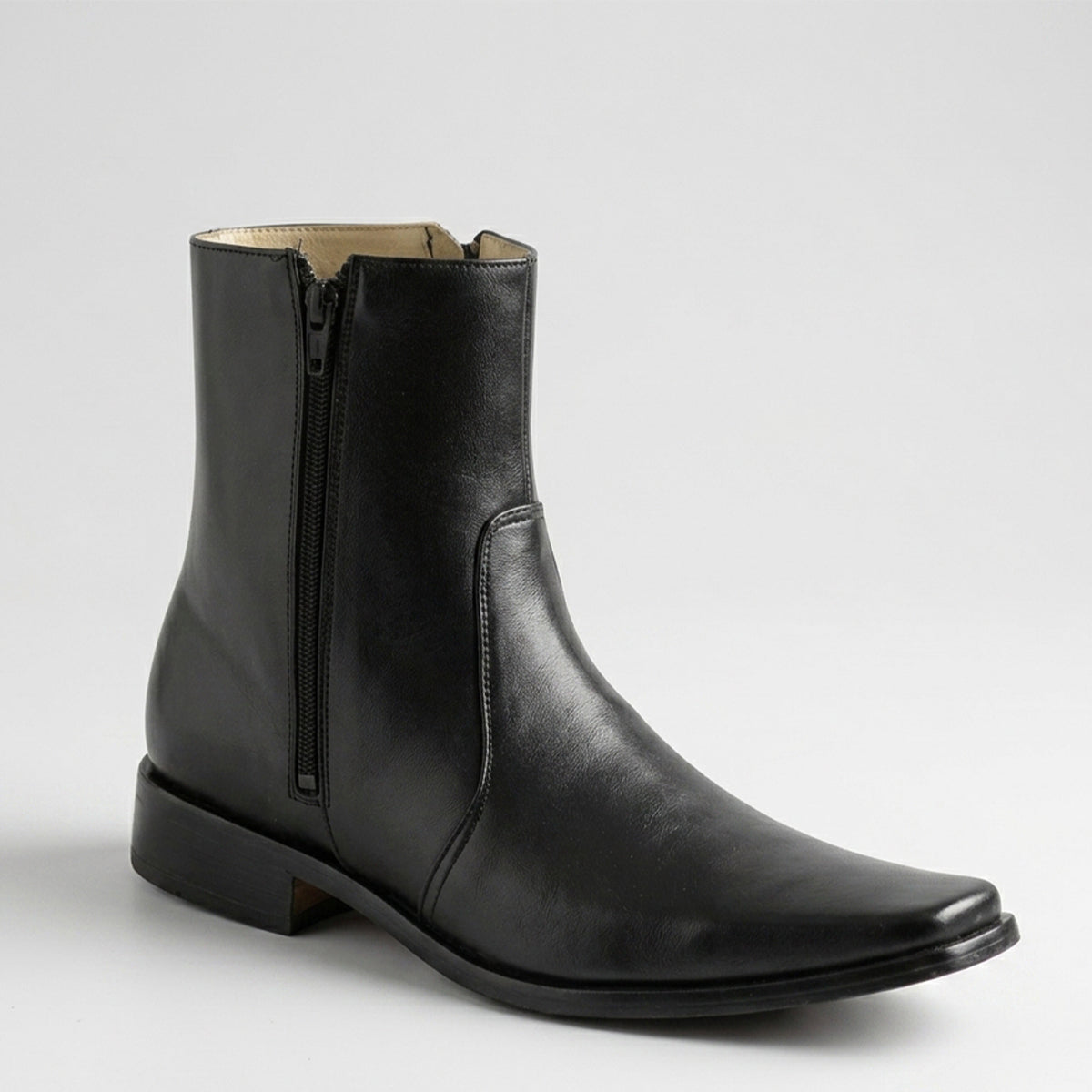 Black leather short ankle boot with a zipper on a light gray background.