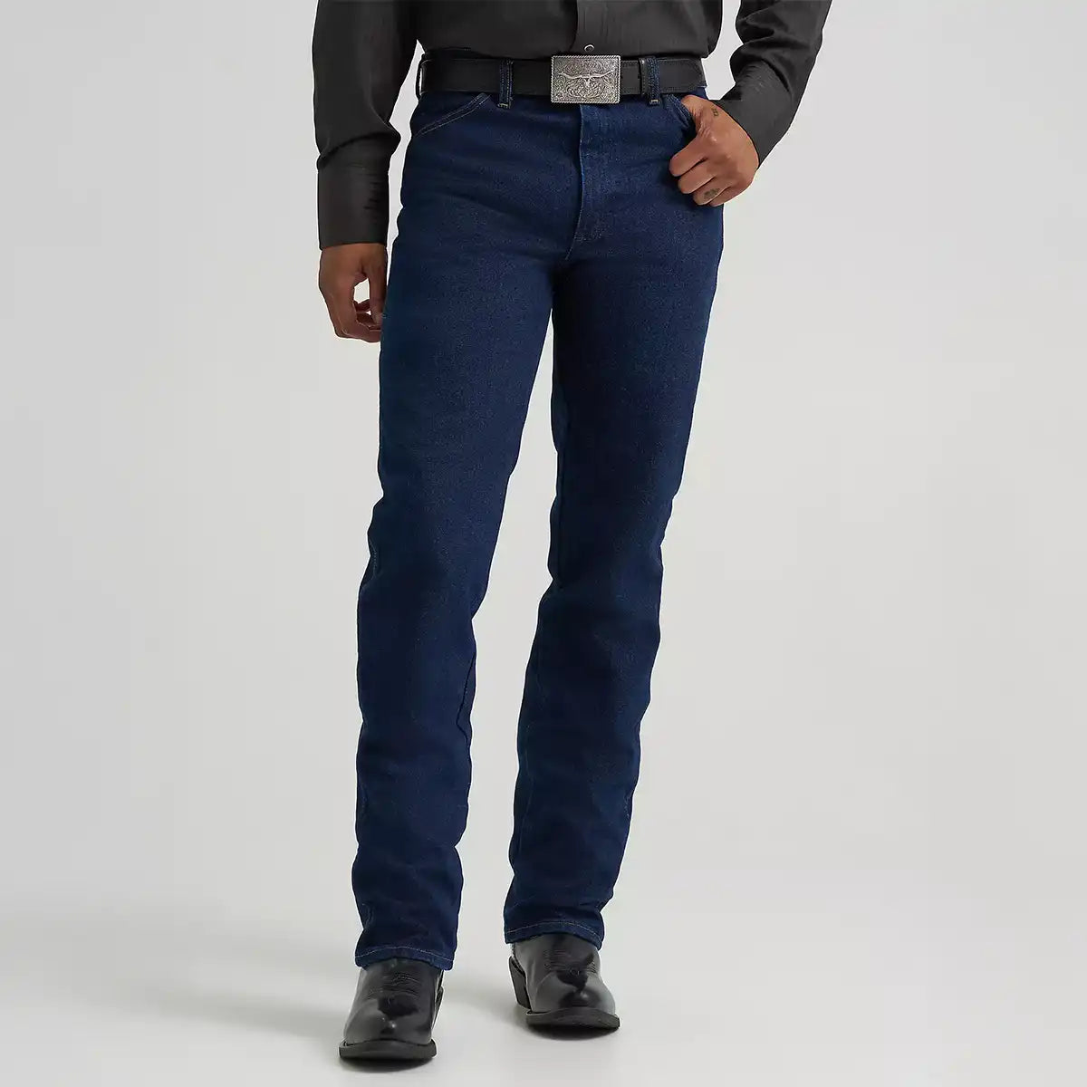 Front profile view of a man wearing Wrangler Men's Cowboy Cut Silver Edition dark denim jeans over black Western boots.