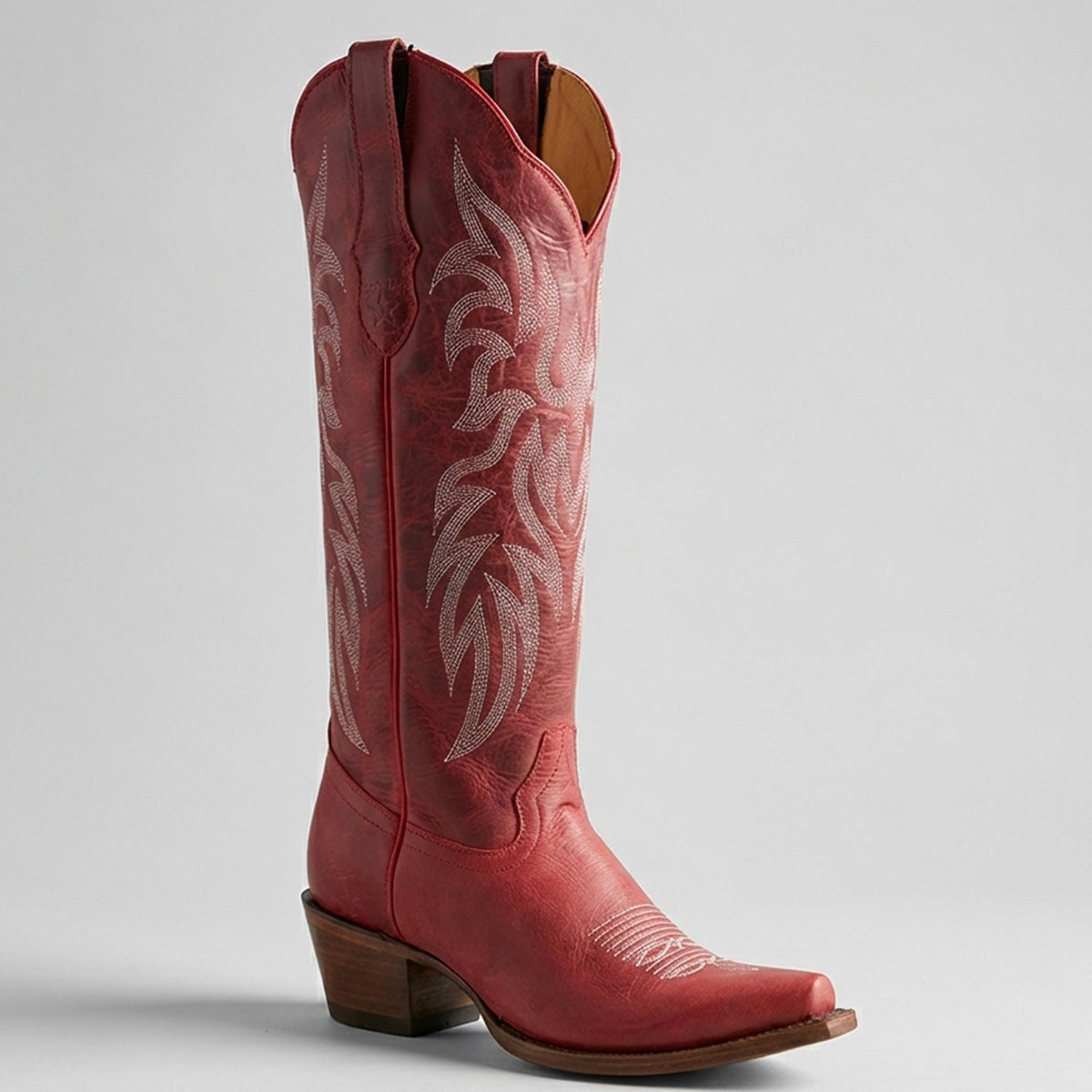 Los Altos women's red leather knew high western boot snip toe profile.