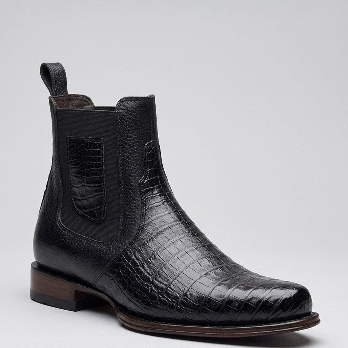 Vestigium men's black caiman belly leather Chelsea boot, featuring a black elastic side panel and pull tab, set against a light gray background.