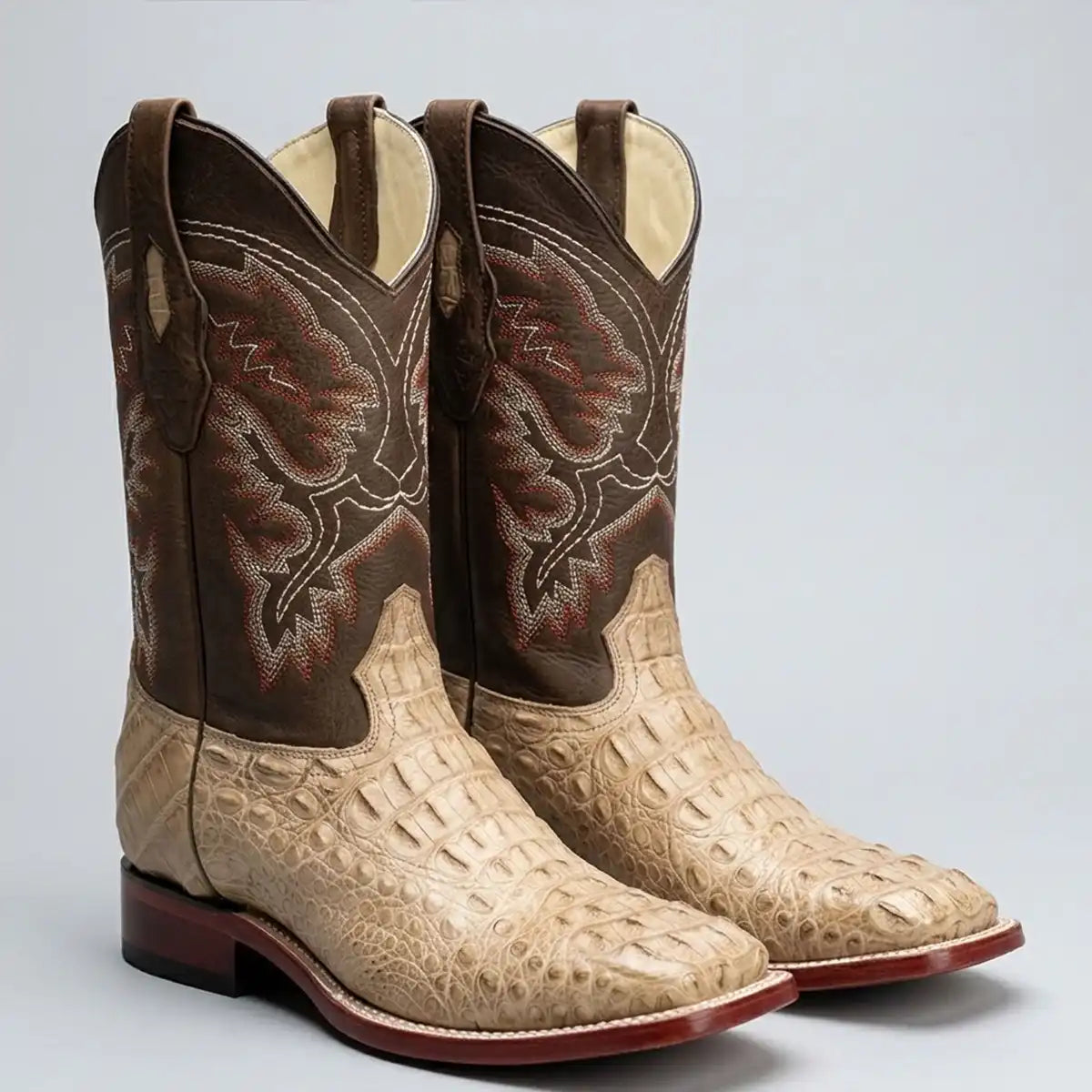 Studio shot of the pair of Los Altos men's honey greasy caiman hornback square toe cowboy boots on a light gray background.