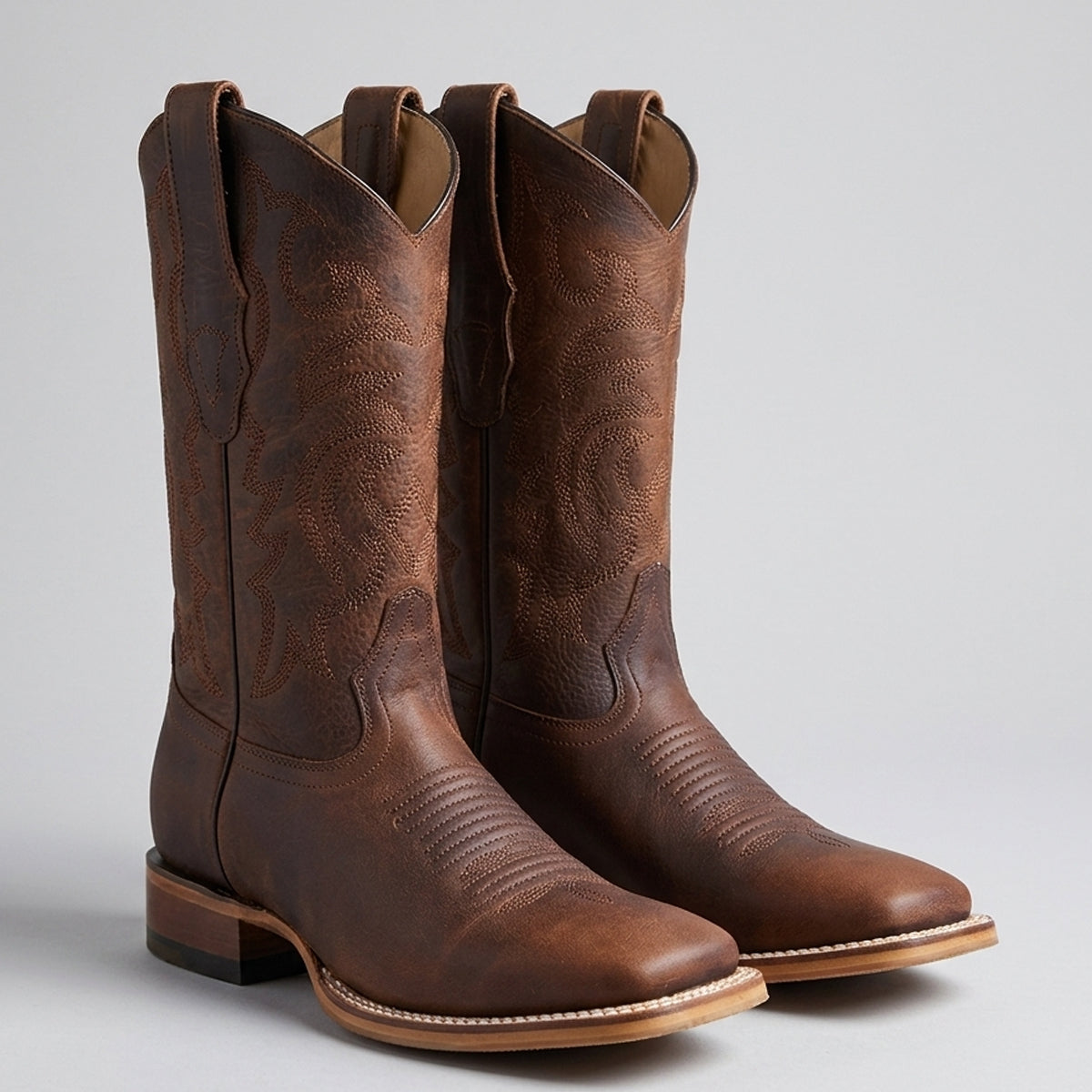 A pair Los Altos dark brown leather square toe cowboy boots with western stitching, shown on a light gray background.
