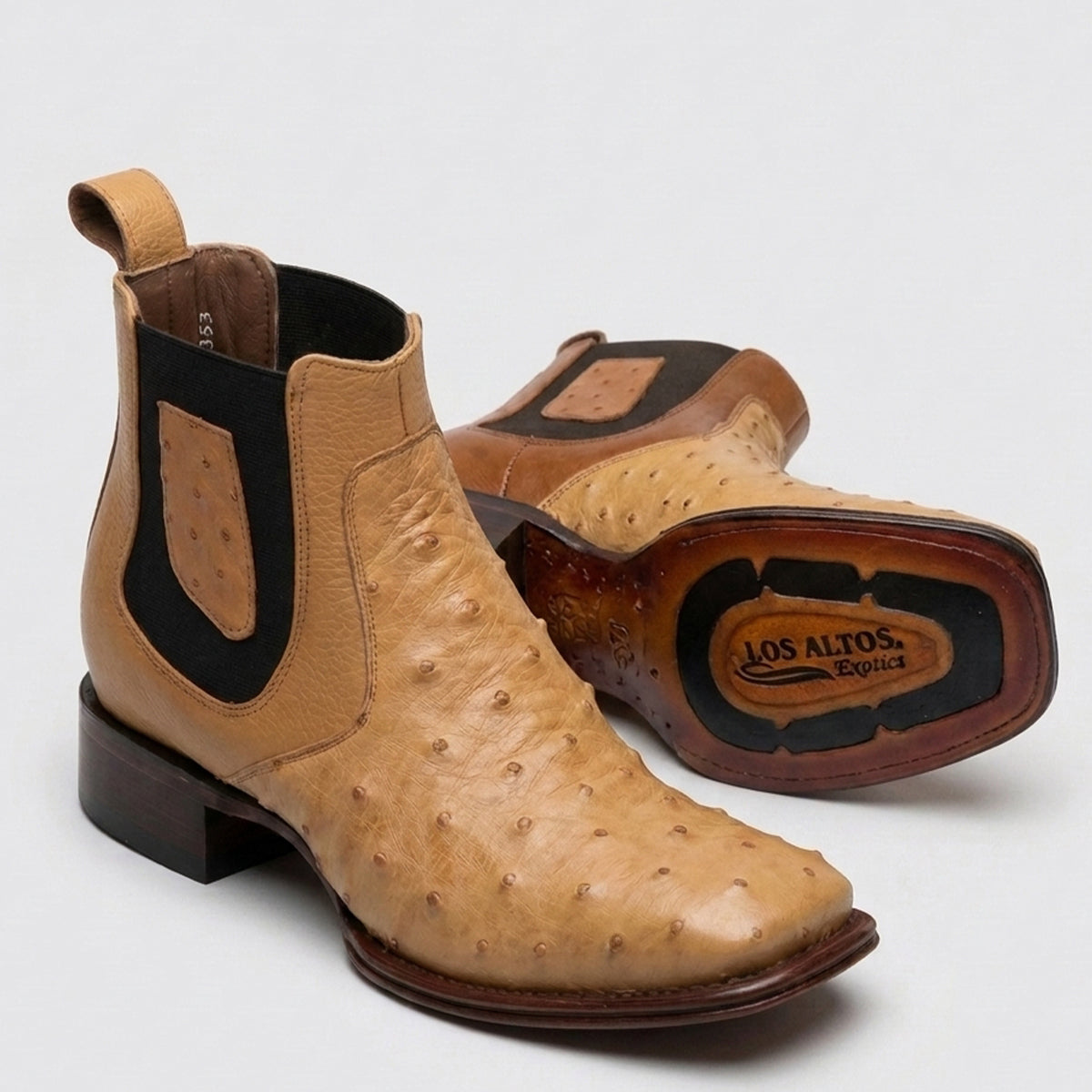 A pair of Los Altos men's tan ostrich leather western boots with black elastic side panels, shown on a light gray background. 