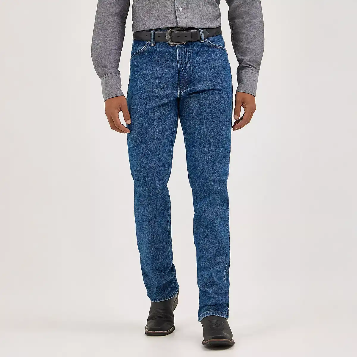Full length front view of a man wearing Wrangler Men's Cowboy Cut slim fit stonewashed jeans with grey Western shirt and black boots.