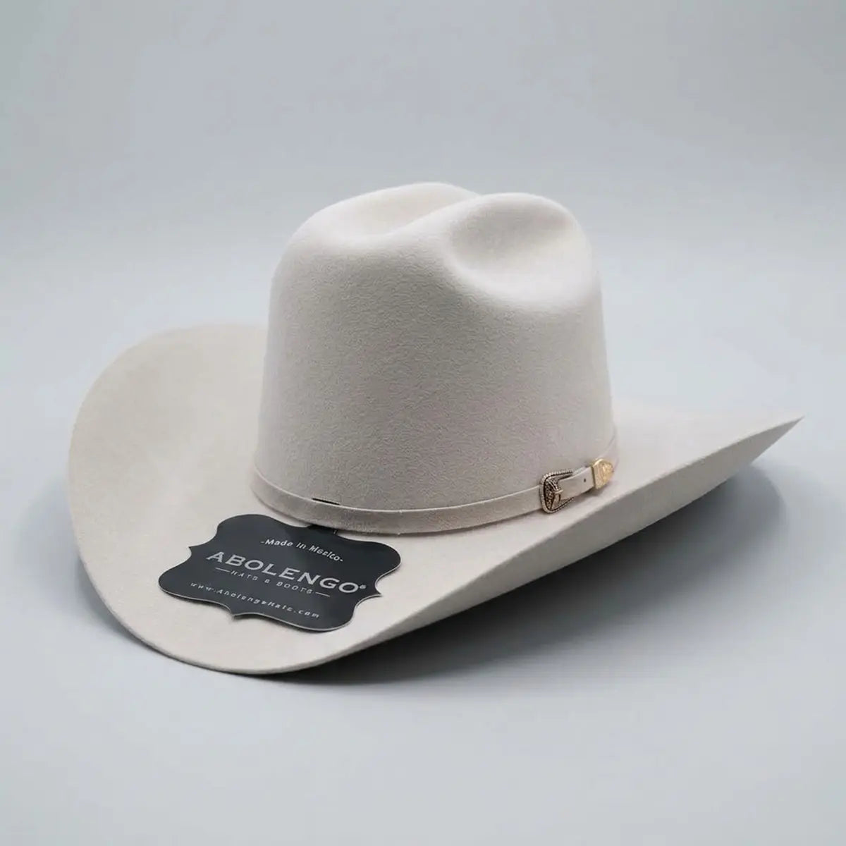 Three-quarter studio profile view of the Abolengo Rancheron 1000X silverbelly rabbit fur felt tejana hat displaying the Cattleman crown crease, silver buckle set, and feather accent.