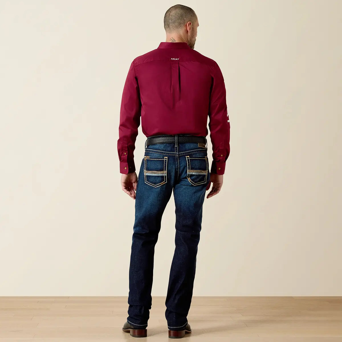 Rear view of the Ariat Men's M7 Rocker Concord jeans highlighting the back pocket stitch detailing, Loop Lock reinforcement, and boot stacking.
