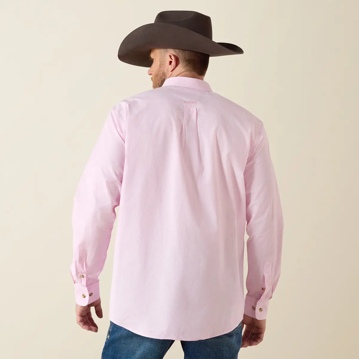 Rear profile view of the model wearing the Ariat Prism Pink Pro Series Dayne shirt showing the back box pleat, pink neck logo, and dark cowboy hat.