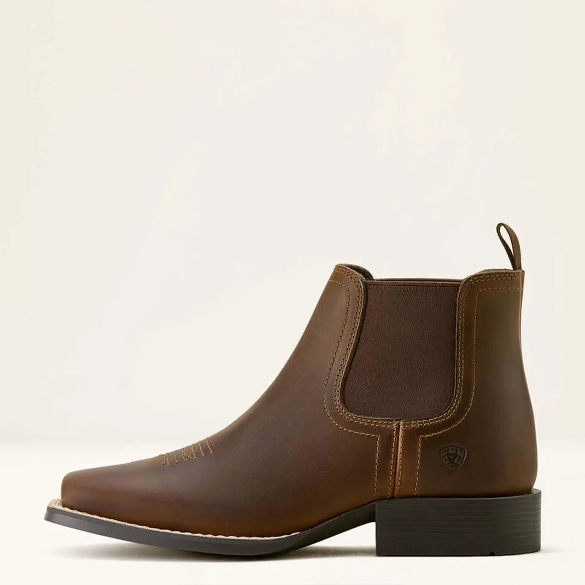 Direct side profile view of the Ariat Kids' Booker Chelsea boot in distressed brown displaying the heel pull loop and embossed Ariat logo.