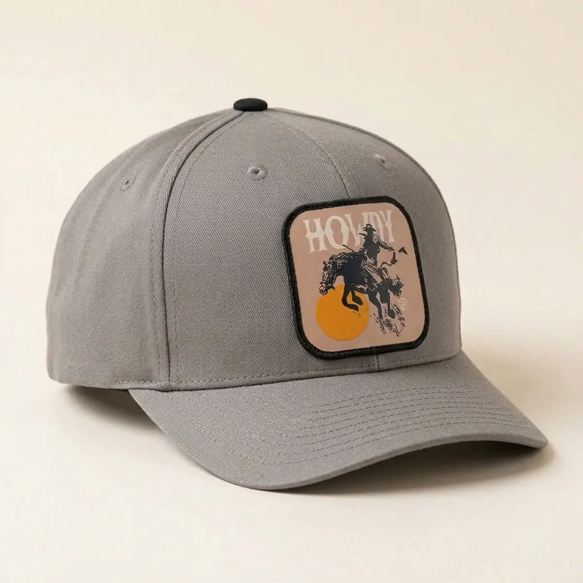 Three-quarter side view of the Rock & Roll Denim grey 100% cotton cap showcasing the Howdy bucking bronco patch and curved visor.