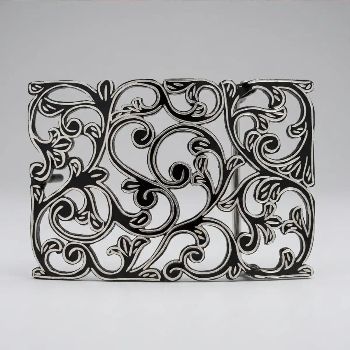 Studio white background view of the 3.5" x 2.5" stainless steel belt buckle displaying the black finish contrast and openwork scrollwork.