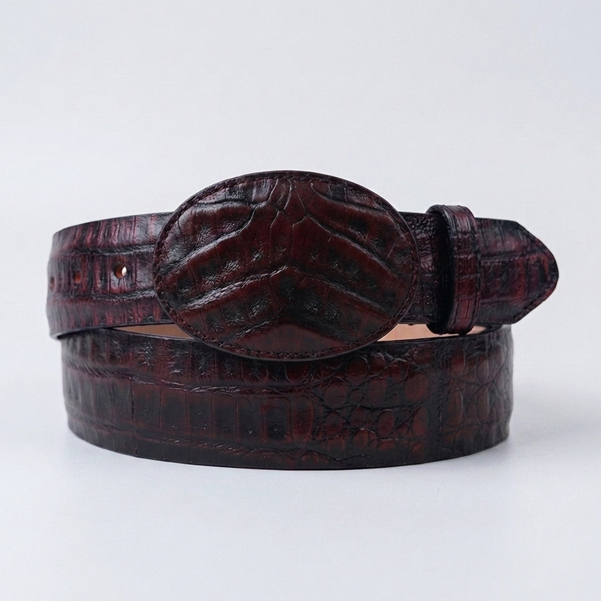 Los Altos men's caiman belly leather belt with a matching oval buckle, coiled on a light gray background.