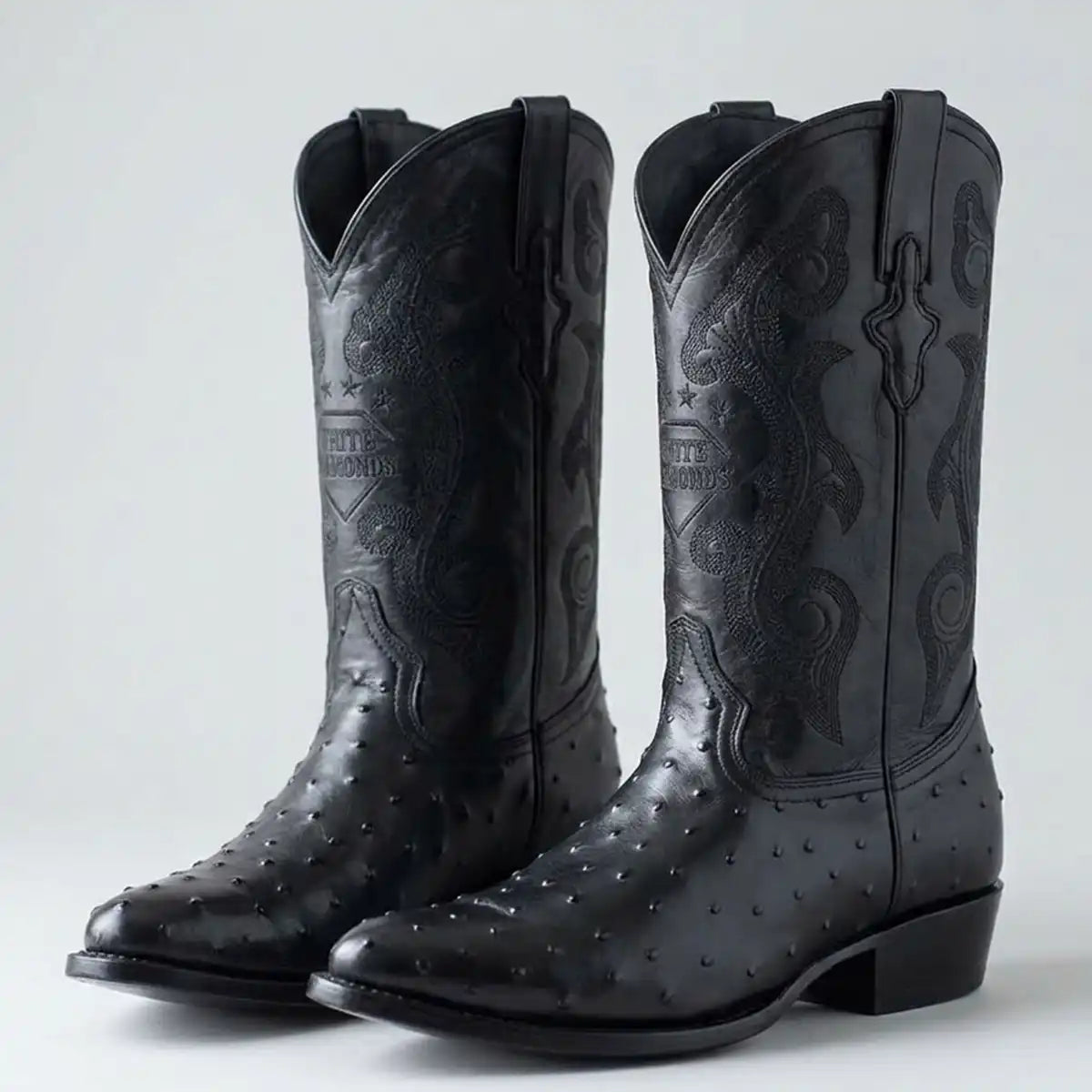 Studio shot of the pair of men's black ostrich print J-toe cowboy boots.