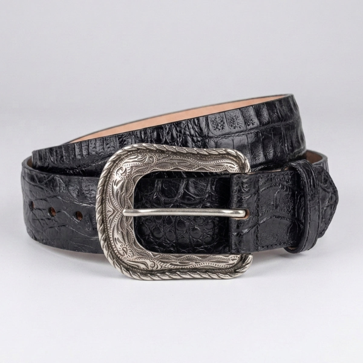 Los Altos men's black crocodile leather belt with a silver-toned western heel-bar buckle, coiled on a light gray background.