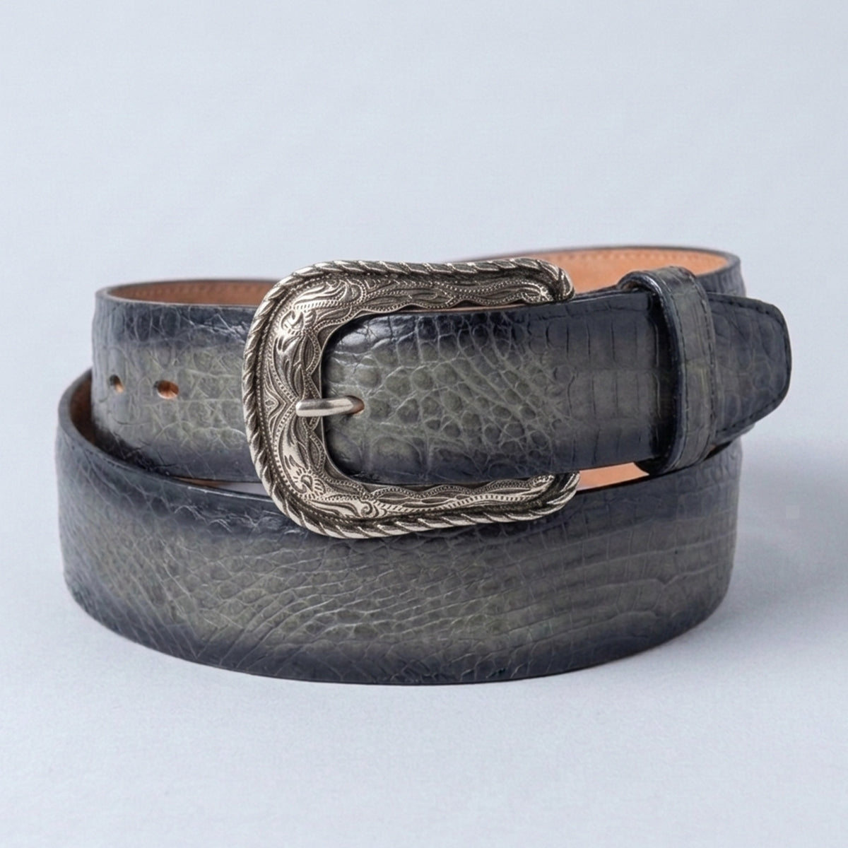 Los Altos men's caiman belly leather belt with a silver western heel-bar buckle, coiled on a light gray background.