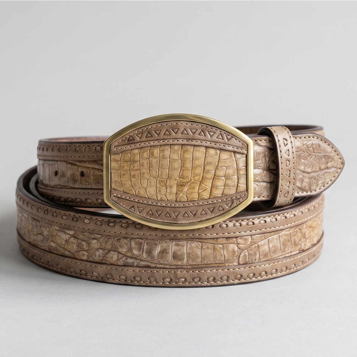 Los Altos men's Sahara Stone genuine caiman belly leather belt showing sandy-taupe scales, laser-carved geometric borders, and a matching gold-tone inlay buckle.