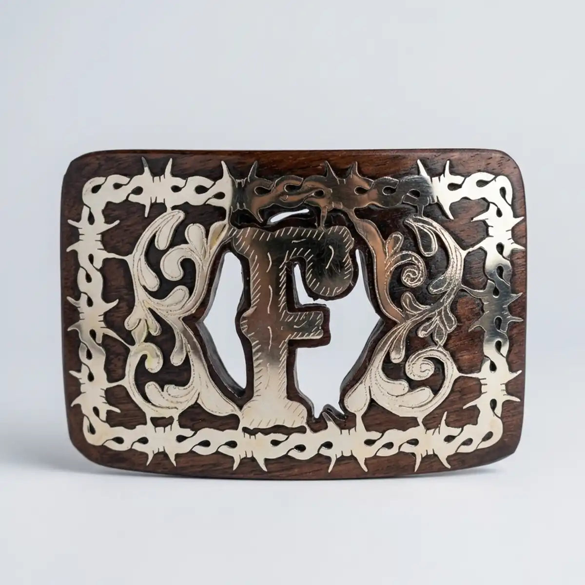Studio white background view of the mesquite wood belt buckle highlighting the polished letter F and intricate scrollwork.