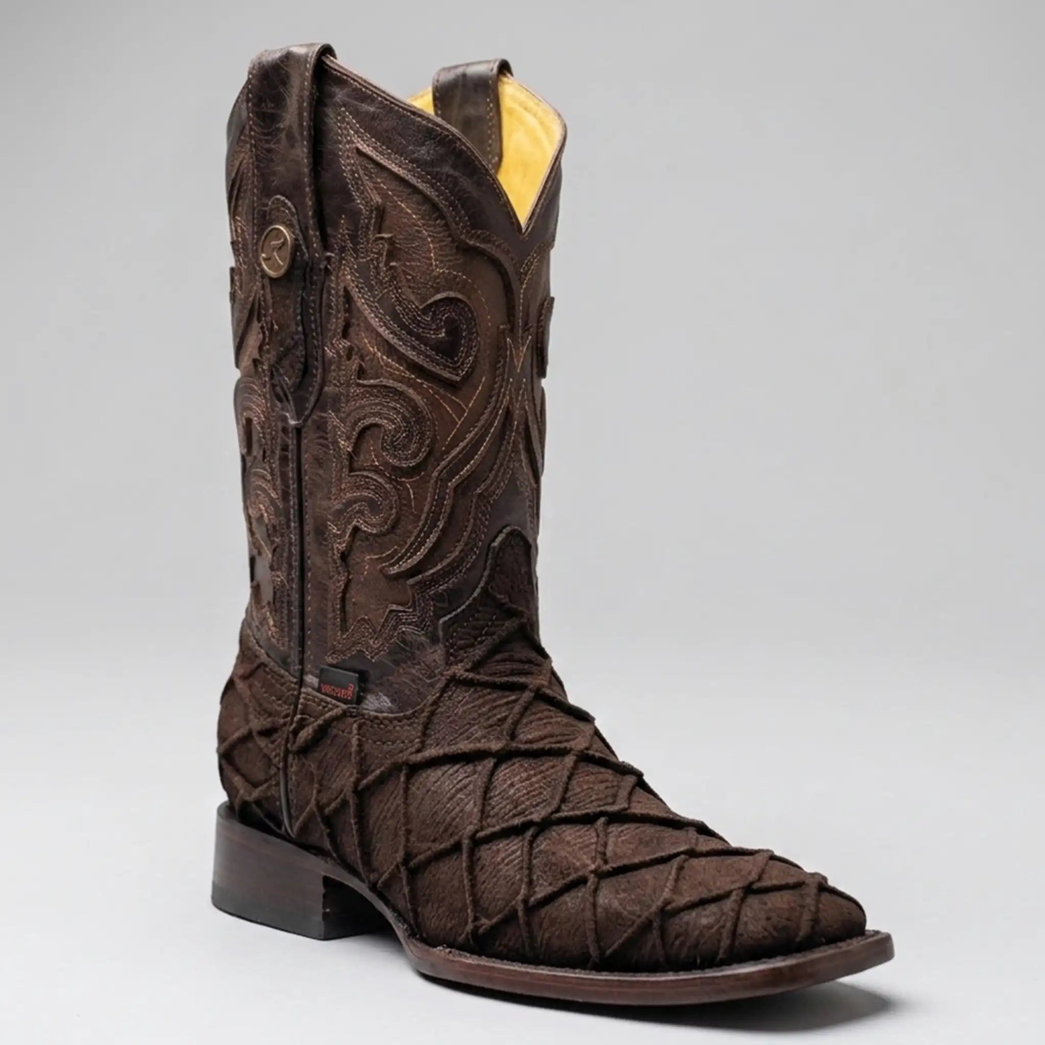 A dark brown Pirarucu fish print cowboy boot with intricate hand-tooled western embroidery on the shaft, a textured woven pattern on the foot, and a square toe, shown against a neutral gray background.