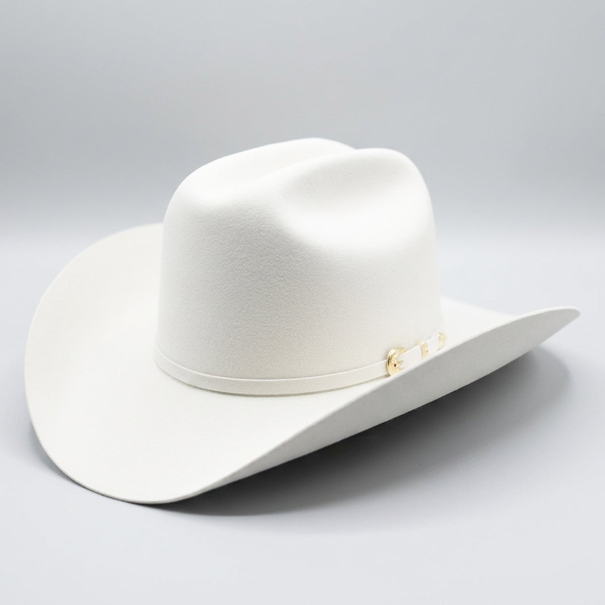 A premium Larry Mahan Real 6X white fur felt cowboy hat featuring a classic cattleman crown crease, a 4-inch brim, and a white felt hatband with a gold buckle set.