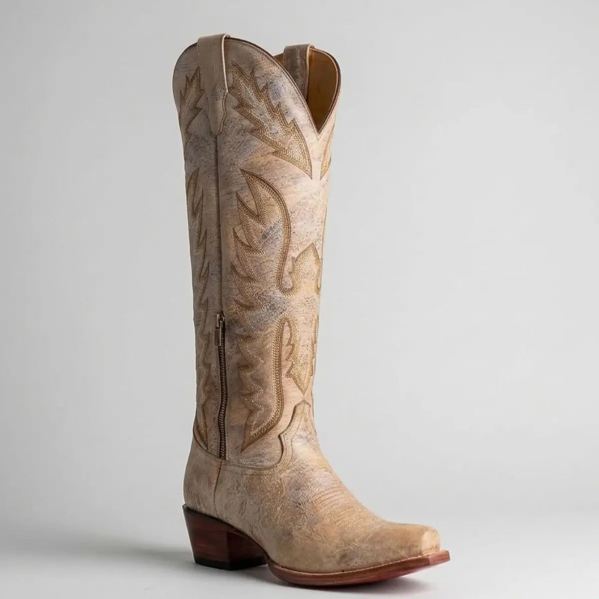 Single profile studio view of the Lirac Appaloosa women's tall bone leather cowboy boot highlighting the lower ankle zipper, Western shaft stitching, and leather outsole.