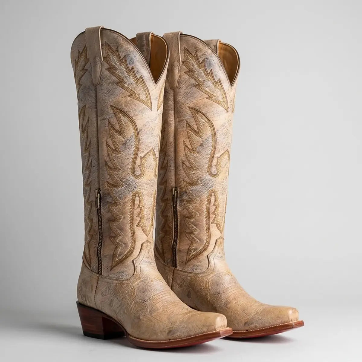 Studio pair view of Lirac Appaloosa women's distressed bone leather tall Western boots displaying the 17-inch embroidered shaft, snip toe, and 2-inch heel on a clean light background.