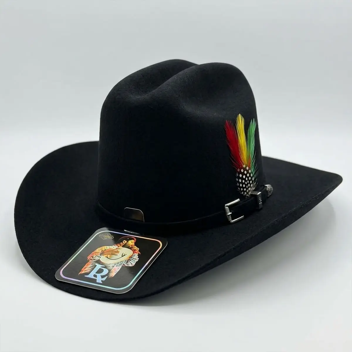 Three-quarter studio view of the official Laredo Hats Luis R. Conriquez black wool blend tejana cowboy hat displaying the 5-inch tall crown, silver buckle, red feather pin, and holographic brand tag.