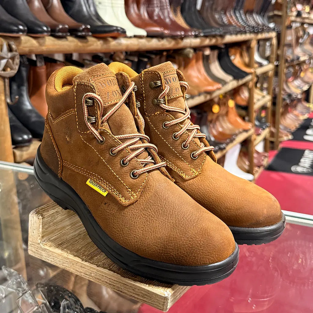 High-angle retail display view of the Work Zone N623 soft toe waterproof work boots sitting on a glass counter inside a storefront.