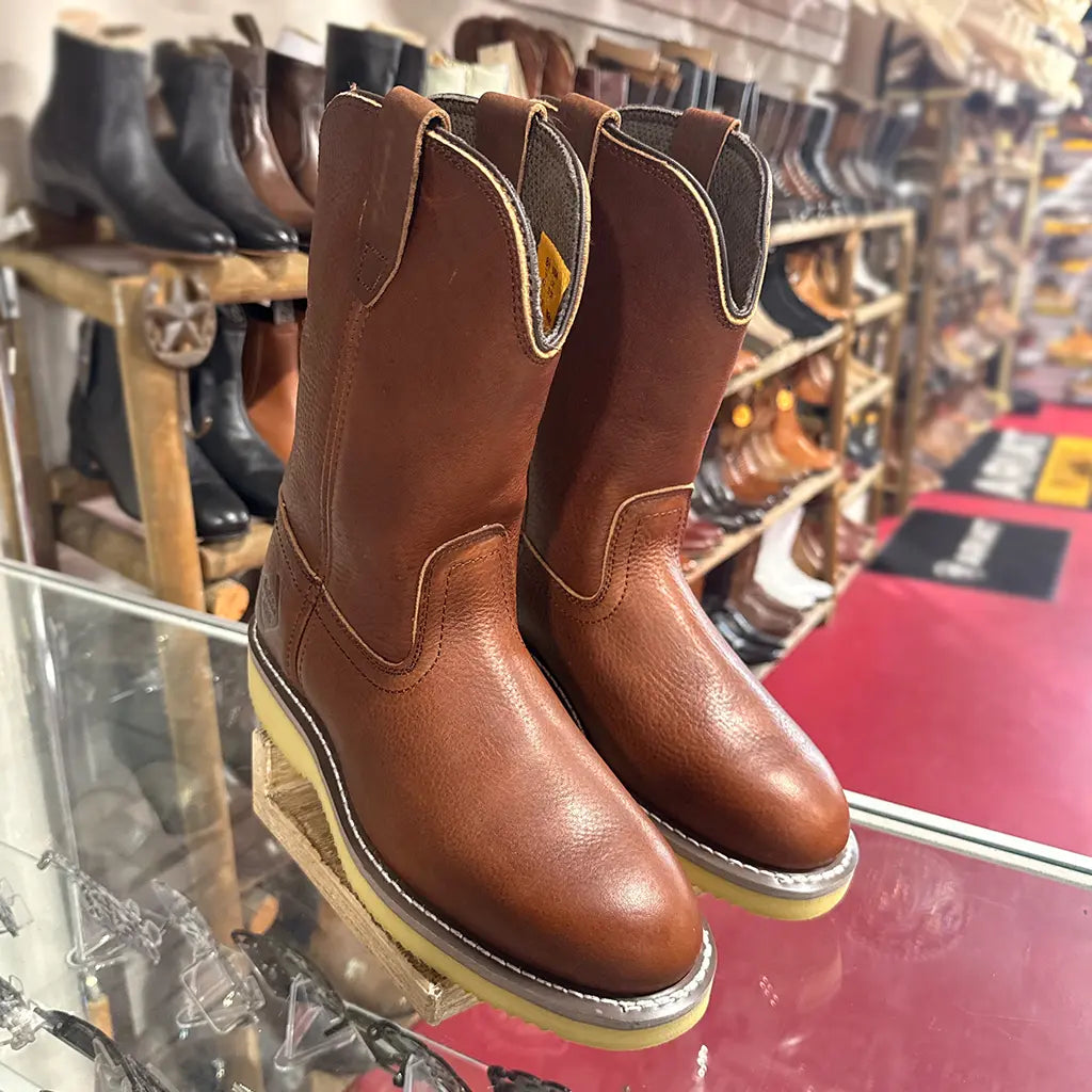 High-angle retail display view of the Work Zone 10-inch Wellington boots sitting on a glass counter inside a boot store.