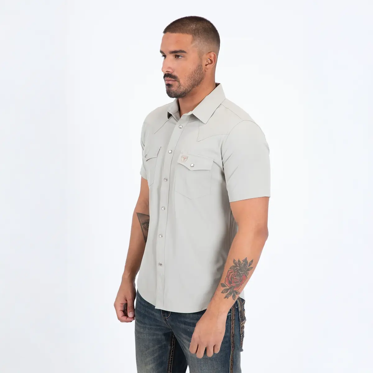 Three-quarter side view of a male model wearing the Platini Prewitt beige short sleeve Western performance shirt.