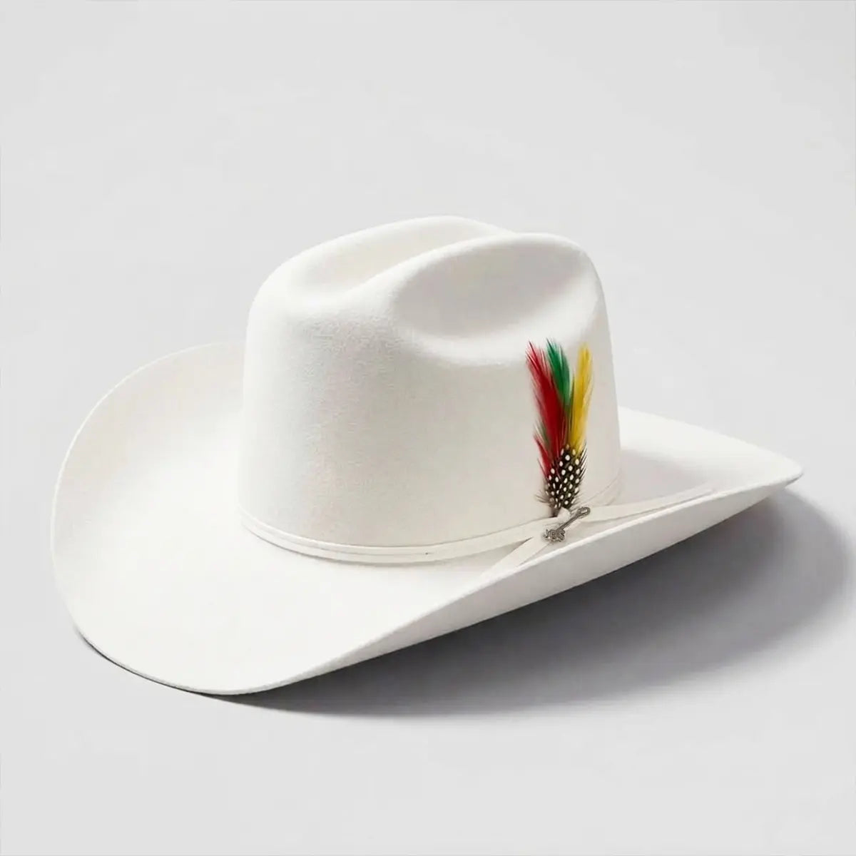 Three-quarter studio view of the Stetson Rancher 6X white fur felt cowboy hat with custom 3.5-inch Sinaloa style brim, tall Cattleman crown, and feather detail.